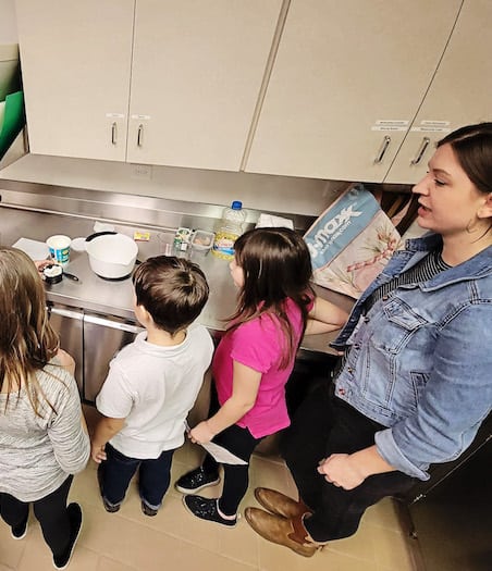 Teacher and kids during a class in the kitchen at school